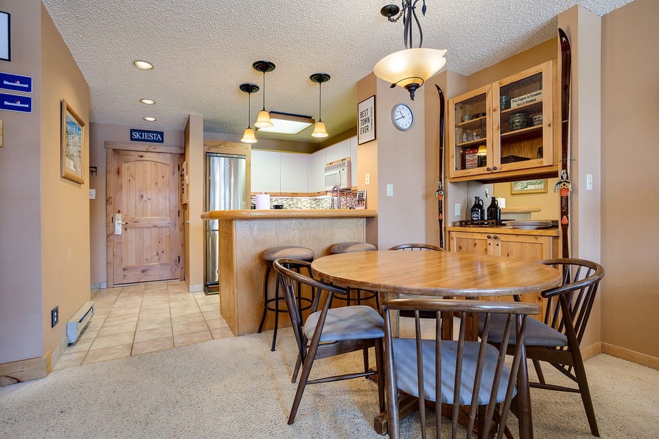 Your cozy mountain-style dining space connects seamlessly to the kitchen, perfect for sharing meals after alpine adventures.
