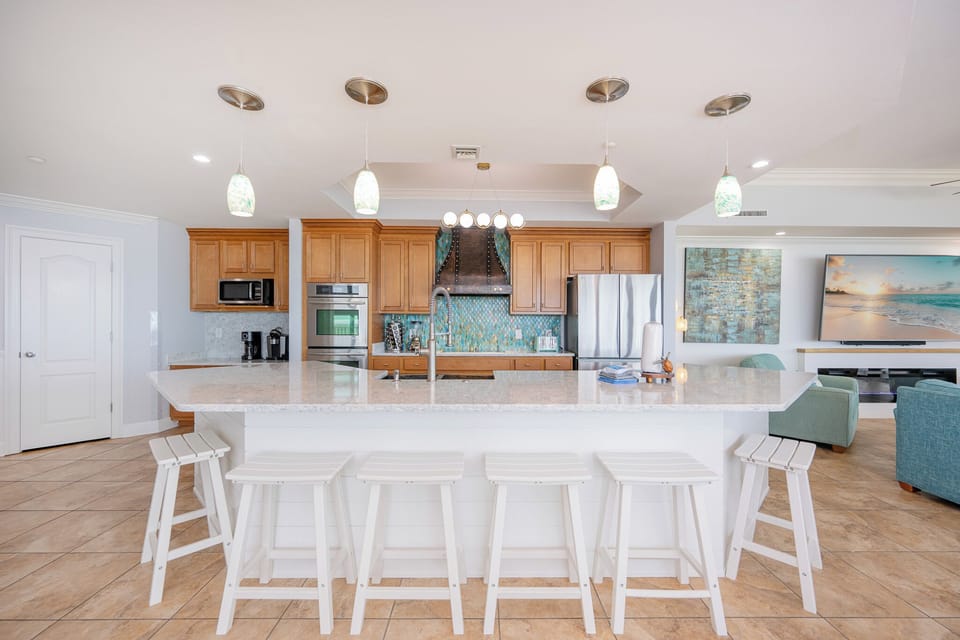 Enjoy casual conversations at the kitchen island, surrounded by stylish seating and vibrant colors that enhance your vibe