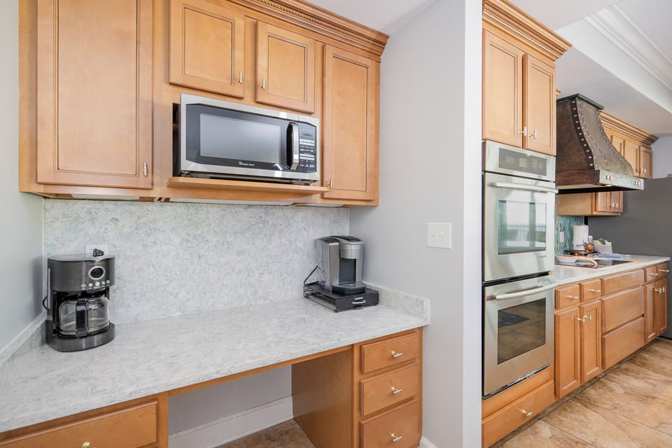Brew your favorite coffee at the counter, surrounded by inviting wood cabinetry and coastal vibes