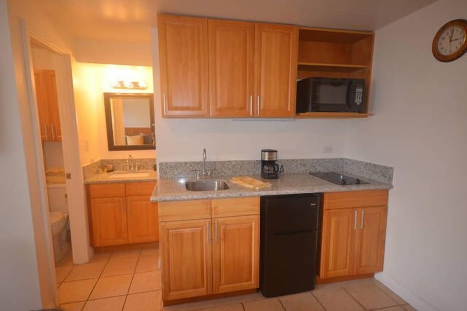 Kitchenette with stove top, sink, mini fridge, and more