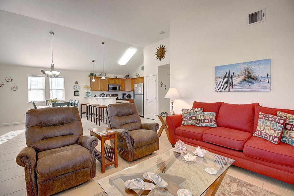 Settle into your bright, open living space where comfortable seating and coastal charm create the perfect retreat for relaxation after beach adventures.