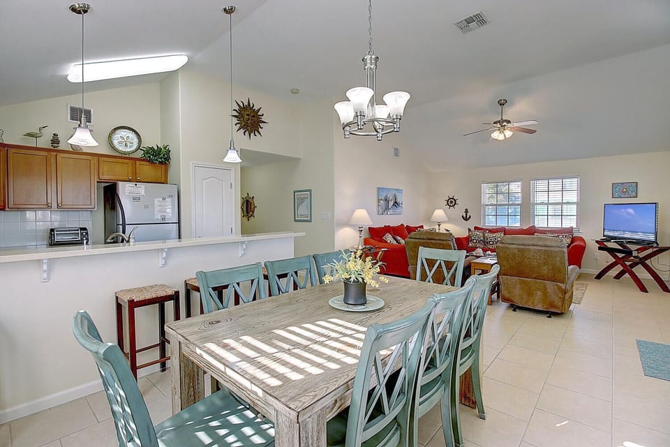Gather around this spacious dining table where your family meals become cherished memories, perfectly positioned between the fully-equipped kitchen and cozy living room.