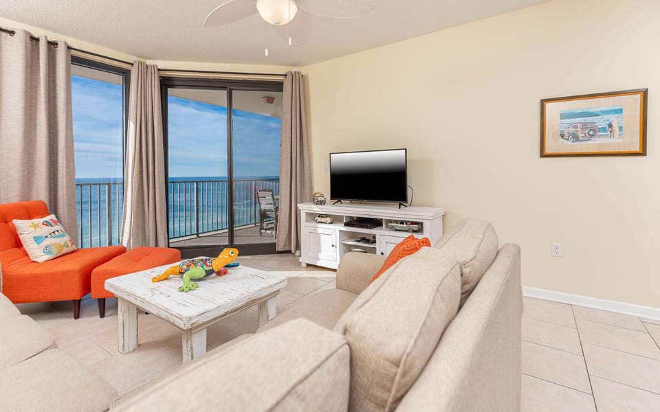Relax in the inviting living area with colorful accents, a large TV, sofa with queen sleeper, and stunning beach views