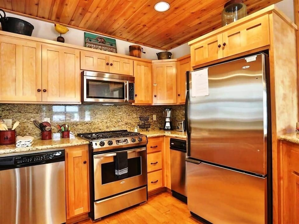 Stainless steel appliances coupled with golden wooden cabinetry and flooring make this kitchen a delightful space to prepare and eat food.