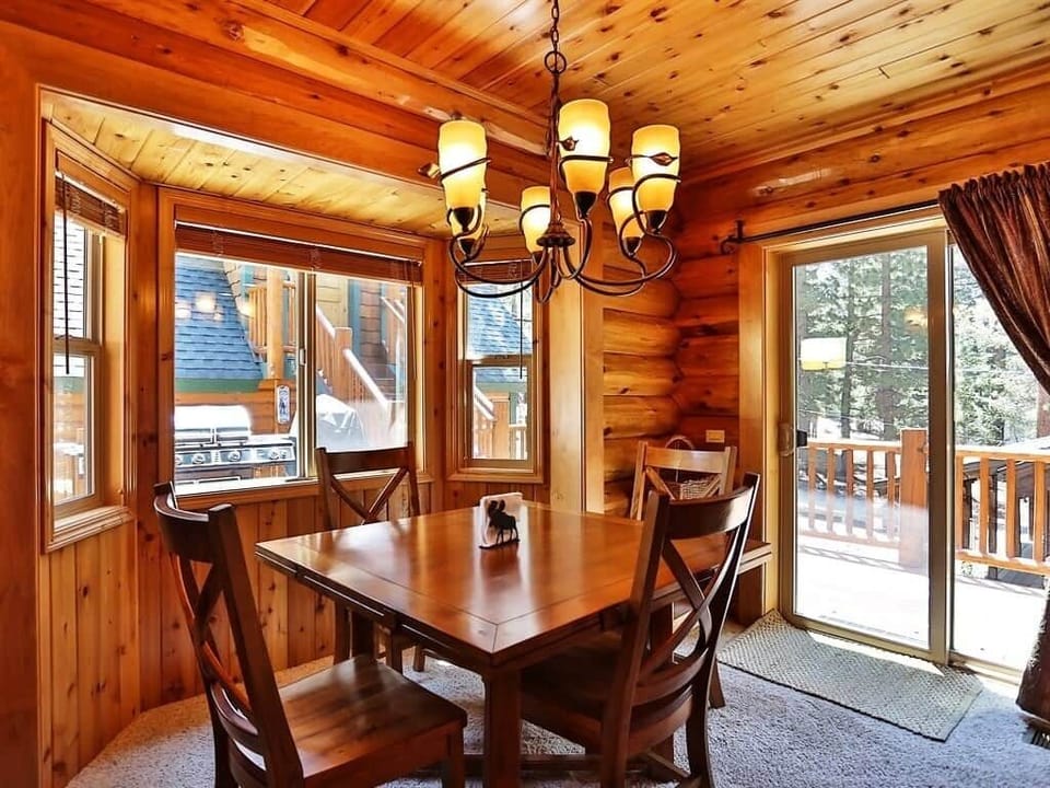 Beautiful wood table with rustic, overhead chandelier and access to patio.