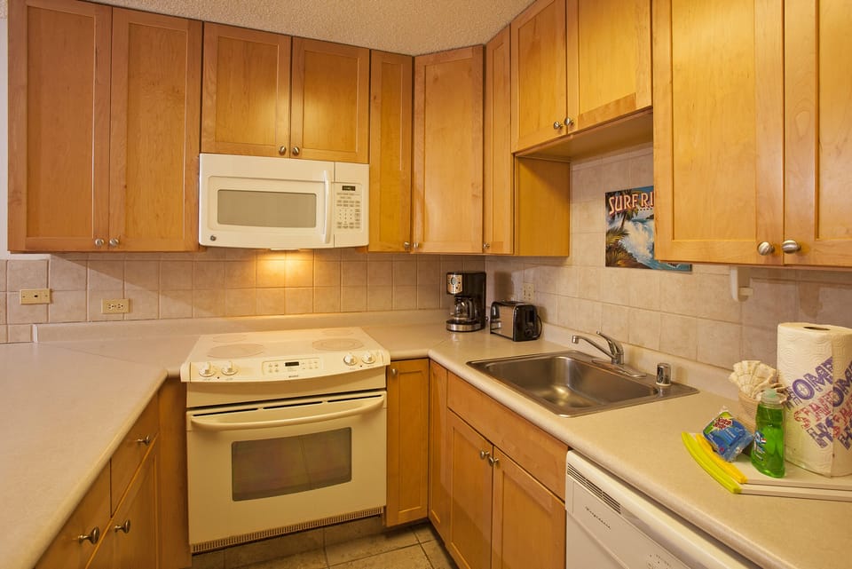 Your fully-equipped kitchen features warm wood cabinetry and modern appliances, making meal prep easy during your stay with a stove, microwave, and dishwasher ready for use.