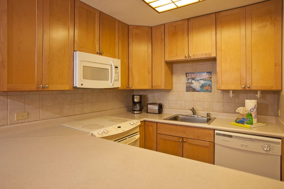 Your fully equipped kitchen features warm wood cabinetry, modern appliances, and everything you need to prepare meals during your stay.