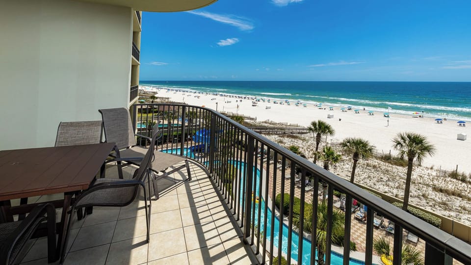 Warm sunlight bathes your balcony as you relax watching waves roll onto the white beach shore below