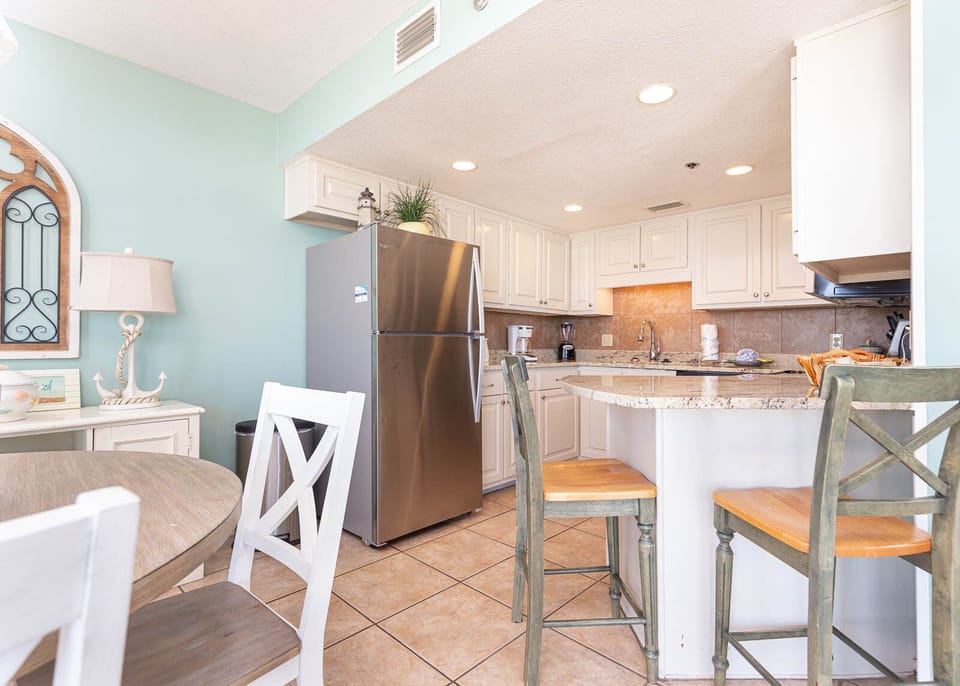 Kitchen area featuring white cabinetry, a granite countertop, and a breakfast bar with seating for a casual dining experience