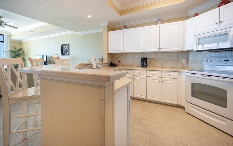 Prepare delicious meals while enjoying the cozy vibe of your beach retreat in this inviting kitchen space