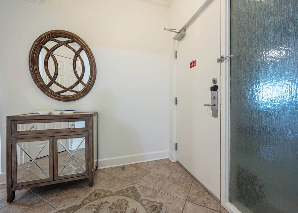 Welcome to your entryway featuring a stylish console table, a decorative mirror, and a cozy area rug for a warm greeting