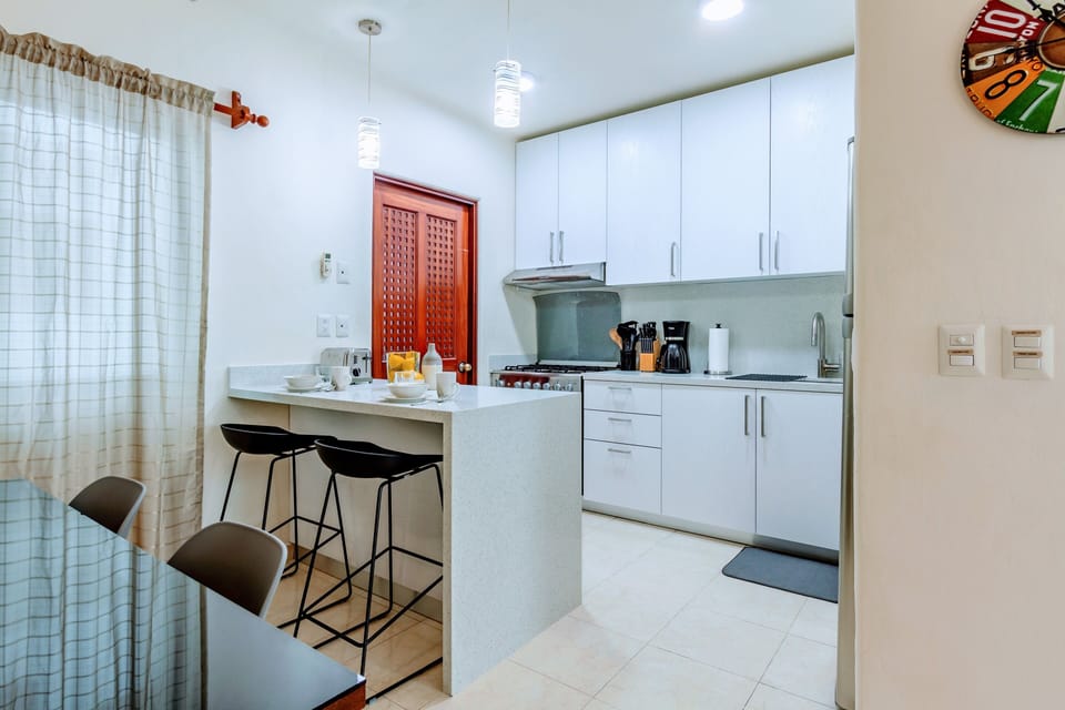 New white quartz counter and modern cabinets Laundry room access viacorner door.