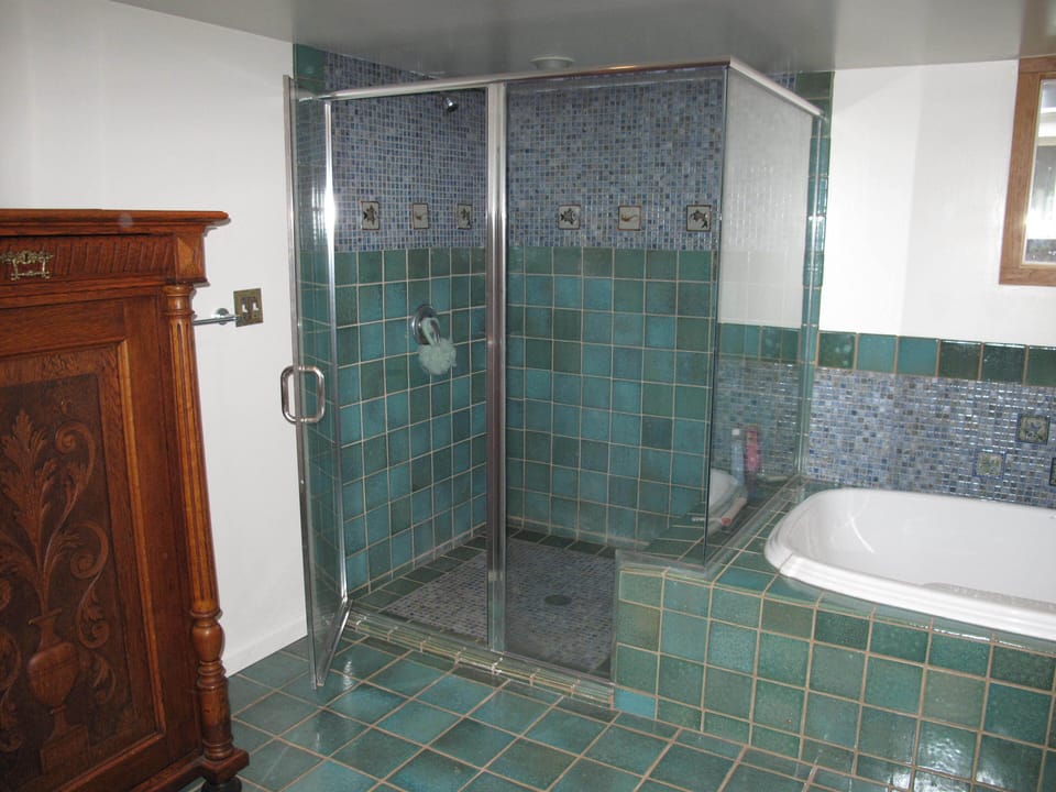 Spacious Shower for 2, with seating Bench. Towel Armoire to the left.