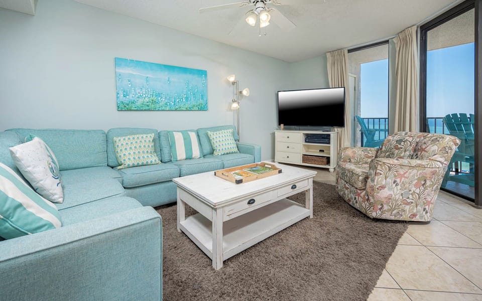 Relax in the inviting living area, featuring a plush sofa with queen sleeper, vibrant decor, and a view of the beach