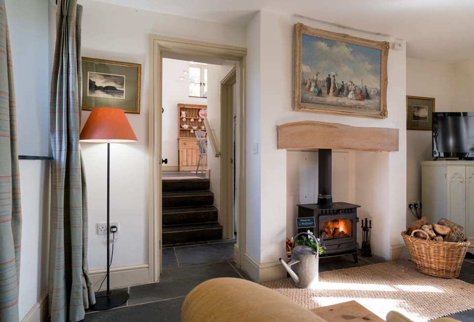 Steps lead down from the kitchen to the sitting room with woodburning stove