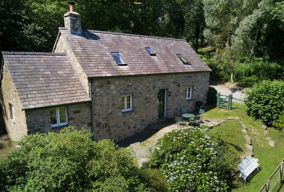 Tyddyn Derwen, nestled in woodland and overlooking a field