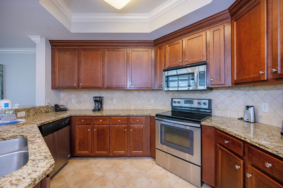 Whip up family favorites with ease in this welcoming kitchen, surrounded by rich wood cabinetry and stainless appliances