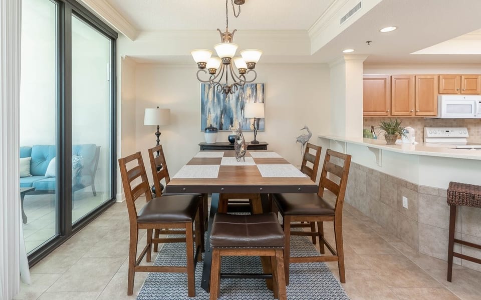 Gather around the elegant dining table surrounded by comfortable seating, with a view of the inviting living area