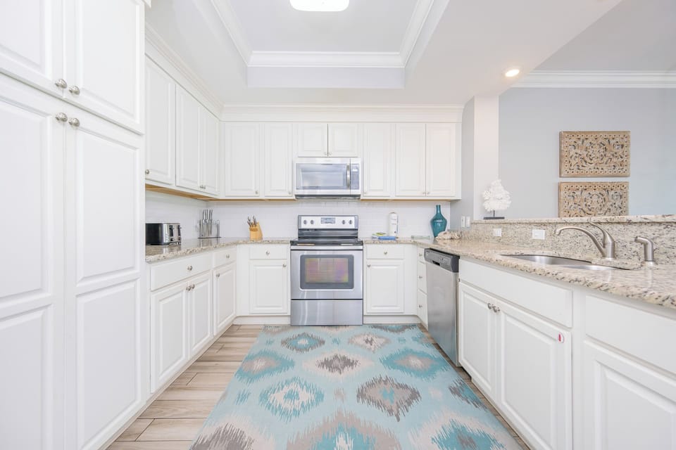 Prepare meals with ease in this bright kitchen featuring granite countertops, stainless appliances, and stylish decor
