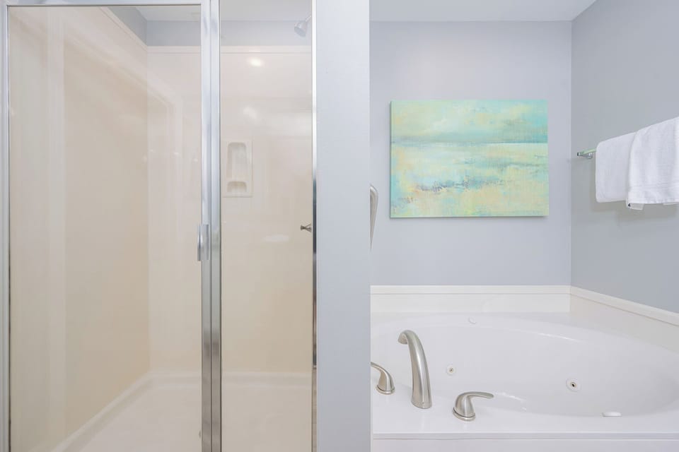 Indulge in relaxation with a spacious jetted tub and a separate walk-in shower in this serene master bathroom