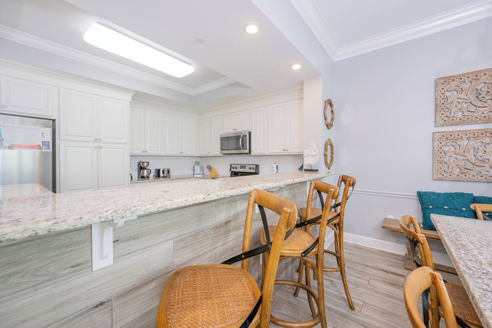 Gather around the stylish bar seating, perfect for casual meals and conversations in this inviting kitchen space