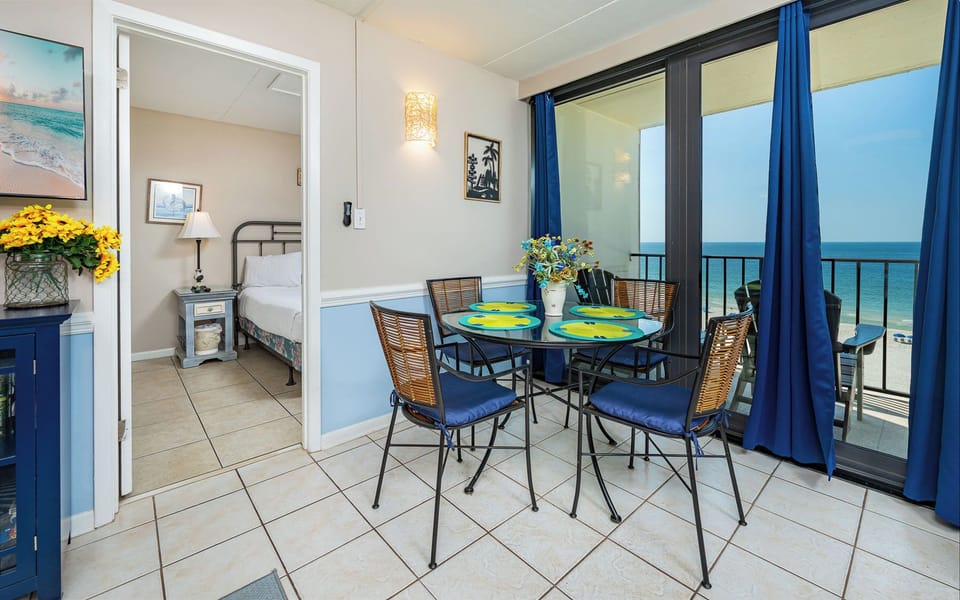 Gather around the cheerful glass table with loved ones, sipping drinks while soaking in the coastal views