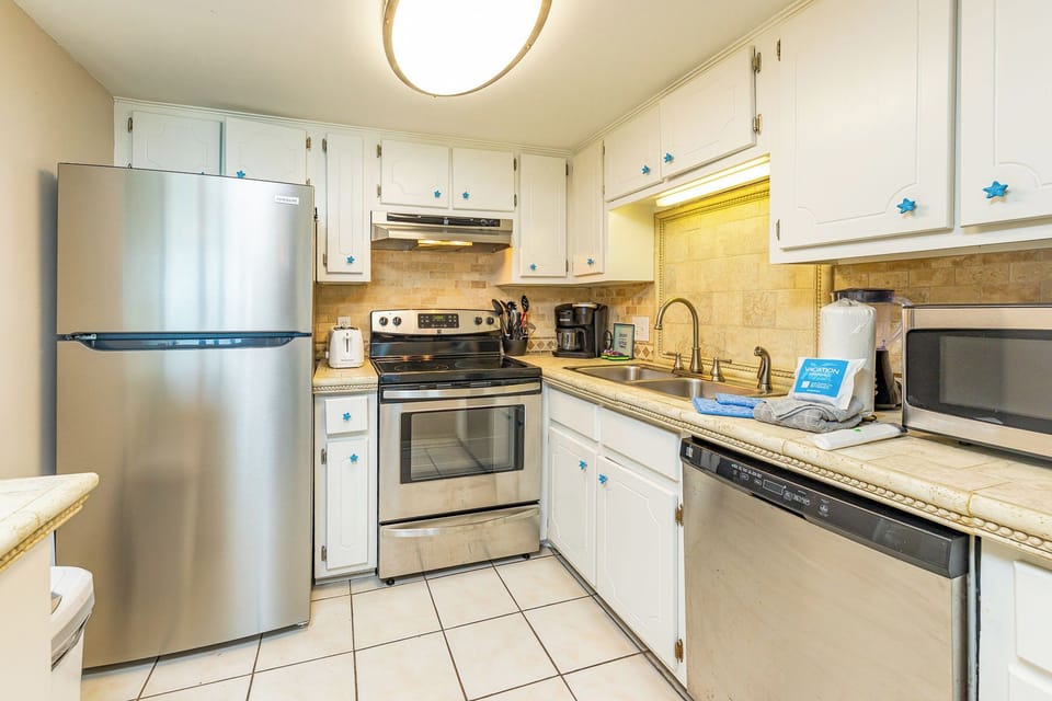 Craft delicious meals together in this inviting kitchen, featuring stainless appliances and charming coastal accents