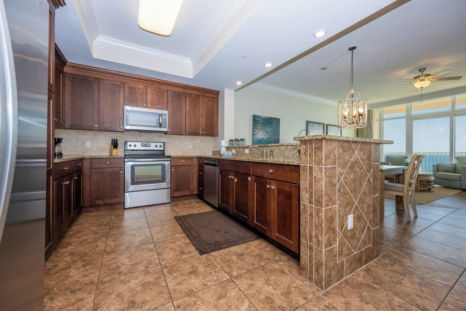 Prepare meals in this stylish kitchen featuring rich wood cabinetry, stainless appliances, and a spacious countertop