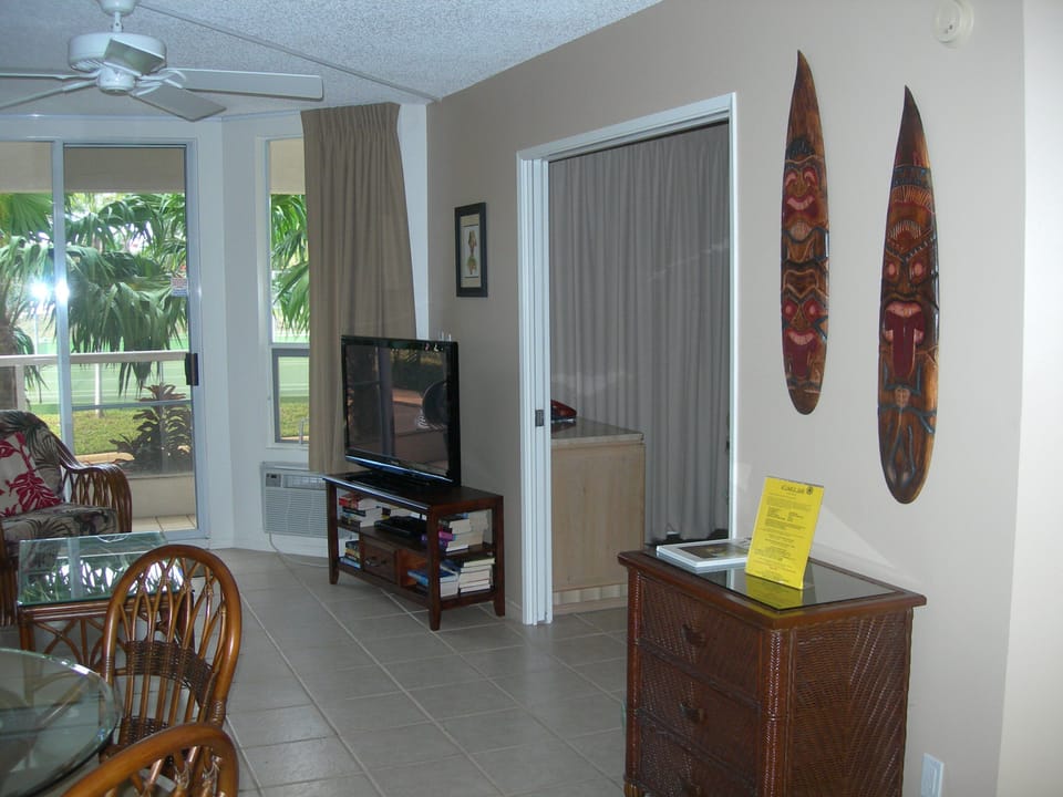 Step into your island-inspired retreat with tropical decor, ceiling fan, and an open living space that flows to lush garden views—ideal for unwinding in paradise.
