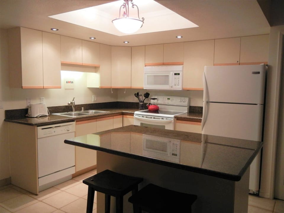 Your fully-equipped kitchen features modern appliances, granite countertops, and a breakfast bar—ready for meals in or island gatherings with loved ones.