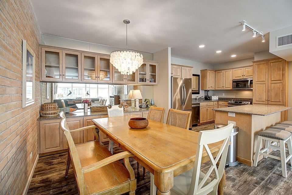 Your open-concept kitchen and dining area features warm wood cabinets, granite countertops, and elegant chandelier lighting for memorable meals.
