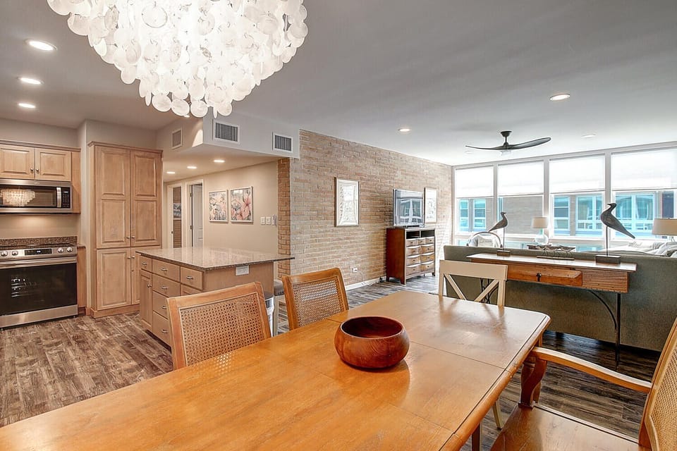 Your modern dining space flows seamlessly into a fully-equipped kitchen, where statement chandelier lighting creates the perfect atmosphere for memorable meals together.