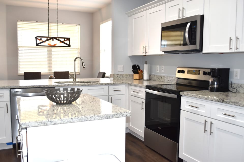 Kitchen with island, granite countertops, and stainless appliances.