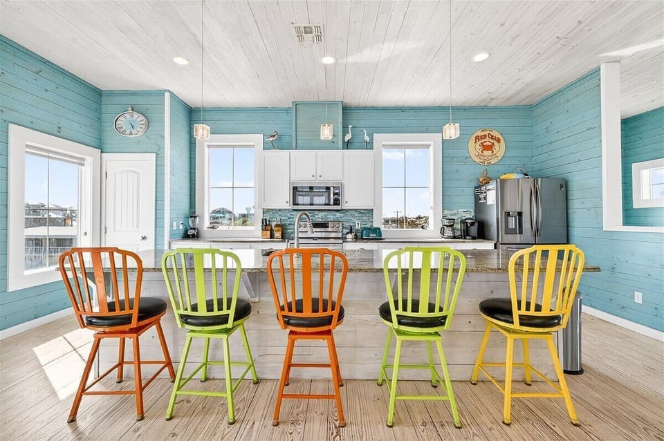 Gather around this cheerful kitchen island with vibrant bar stools where your group can share meals and create memories together.