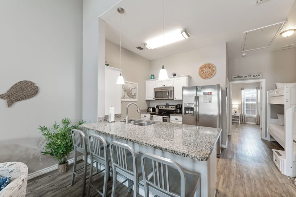 Your bright open kitchen awaits with granite counters, stainless appliances, and a breakfast bar perfect for morning coffee or evening conversations.