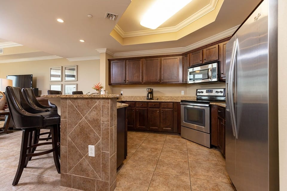 The kitchen features stainless appliances, granite countertops, and a cozy breakfast bar, perfect for morning coffee