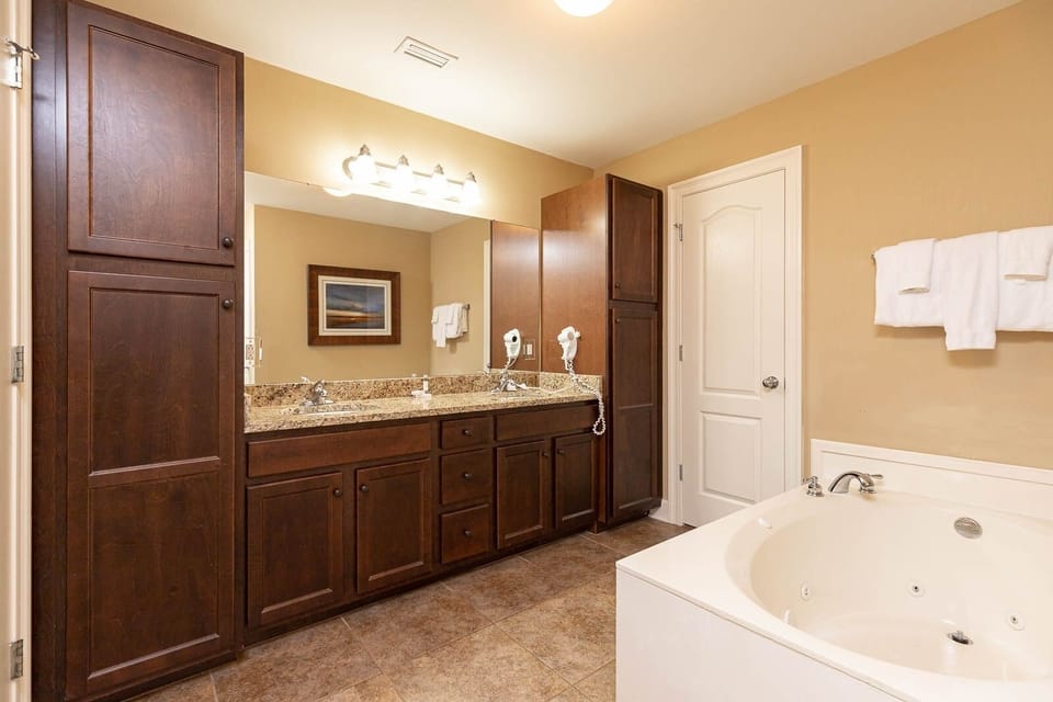 The master bath features elegant cabinetry, granite countertops, jetted tub, and walk-in shower for a rejuvenating experience