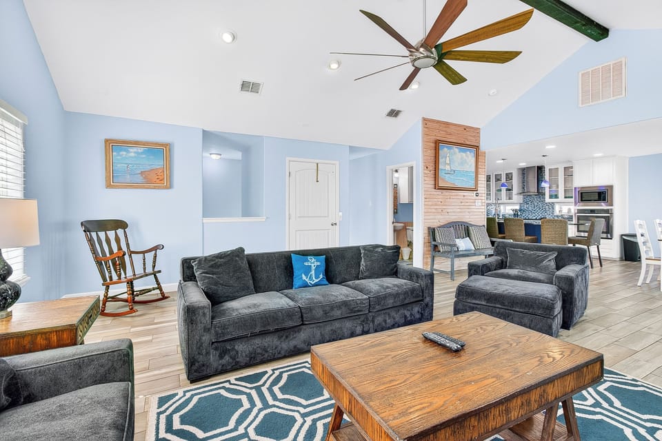 Relax in your coastal-inspired living room where vaulted ceilings and nautical décor create the perfect beach house atmosphere for unwinding after seaside adventures.