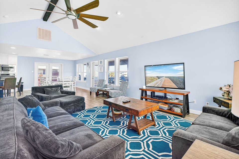 Sink into plush sofas while enjoying your favorite shows on the large TV in this bright, airy living space.