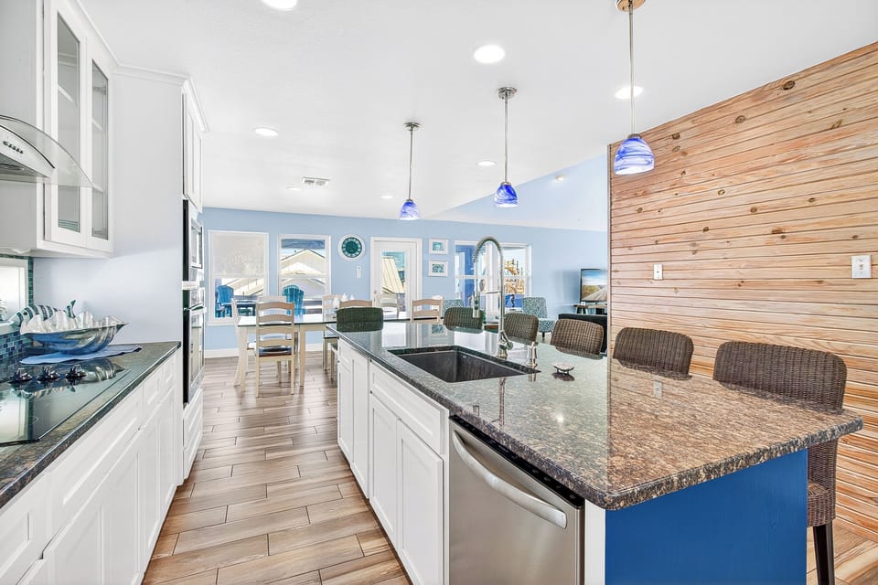 Cook and gather around this stunning granite island with modern appliances and coastal charm throughout your spacious kitchen.