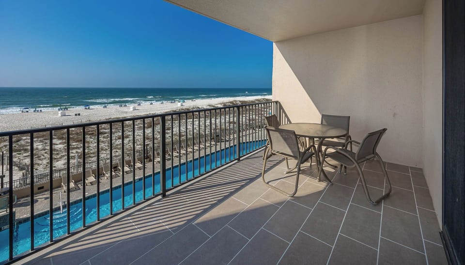 Relax at the outdoor table while enjoying views of the beach and the inviting pool area below