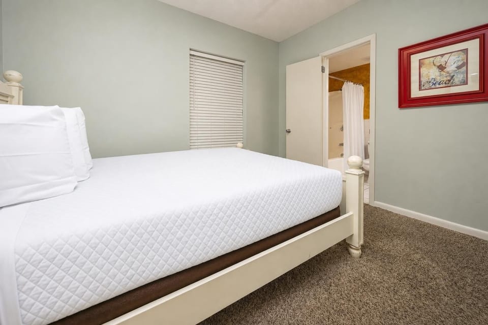 Rest in this inviting guest bedroom featuring a queen bed, soft carpet, and easy access to the adjoining bathroom