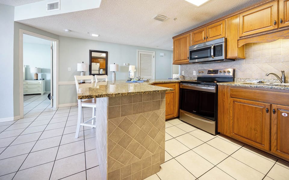 Prepare meals in the inviting kitchen featuring granite countertops and stainless appliances, perfect for your vacation