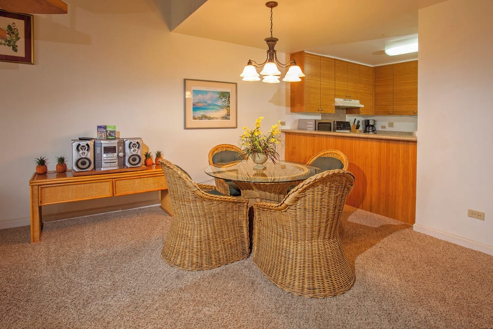 Gather around the charming wicker dining table, where sunny yellow flowers and warm tropical touches create your perfect home-away-from-home setting for memorable island meals.