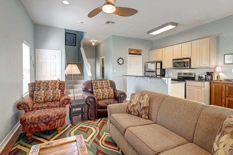 Relax in your open-concept living space where comfortable seating flows seamlessly into a fully-equipped kitchen, perfect for memorable family gatherings.