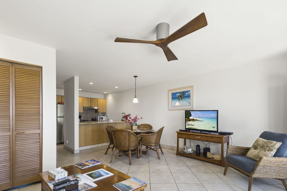 Your open-concept living space blends comfort and function, with a ceiling fan keeping you cool, a cozy dining nook, and beach-inspired touches creating a relaxed island vibe.
