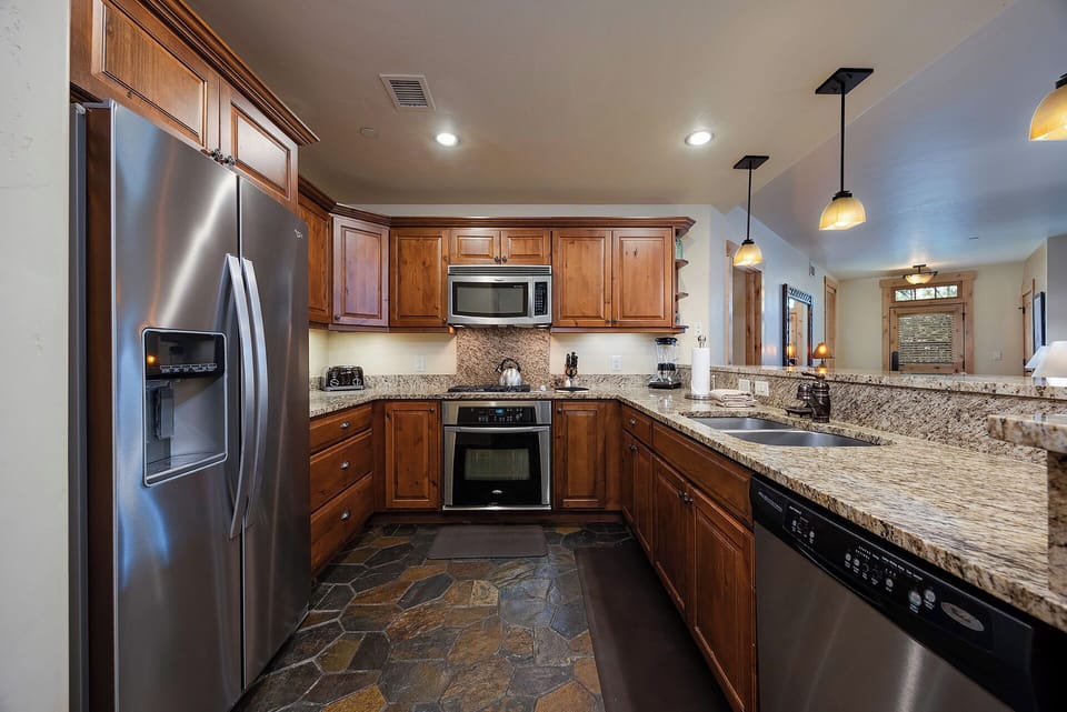 Your gourmet kitchen awaits with stainless steel appliances, granite countertops, and rich wood cabinetry—perfect for preparing home-cooked meals during your stay.
