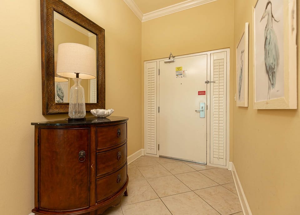 Step into a welcoming entryway adorned with a stylish mirror and a cozy lamp, setting the tone for your beach getaway