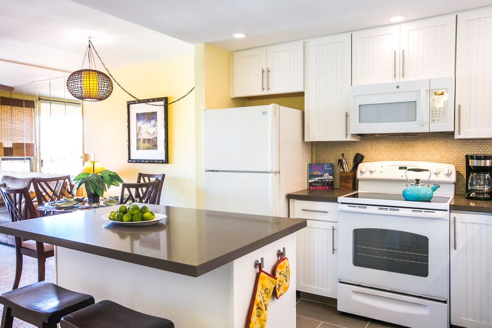 Your fully equipped kitchen invites you to prepare meals with crisp white cabinetry, modern appliances, and a spacious breakfast bar for morning coffee or casual dining.