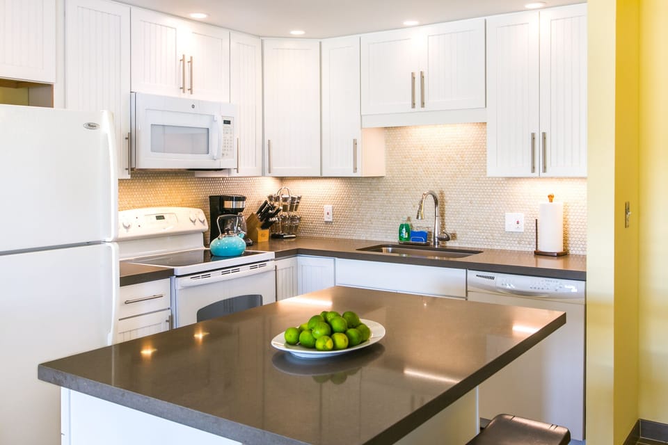 Bright, fully-equipped kitchen with sleek white cabinetry, modern appliances, and a center island—perfect for whipping up your favorite meals in style during your stay.